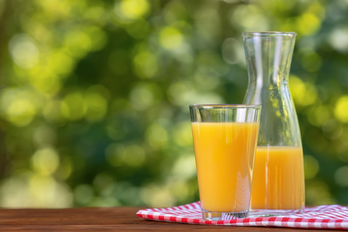 Eine Karaffe mit Orangensaft neben einem gefüllten Glas